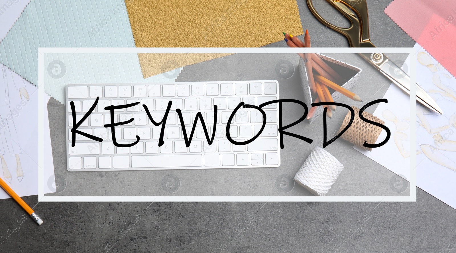 Image of Text KEYWORDS over designer's workplace with keyboard and accessories, flat lay