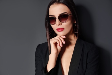 Photo of Beautiful woman wearing jacket and sunglasses on black background