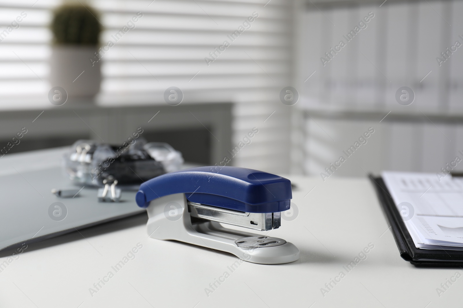 Photo of Stapler on white table indoors, closeup view