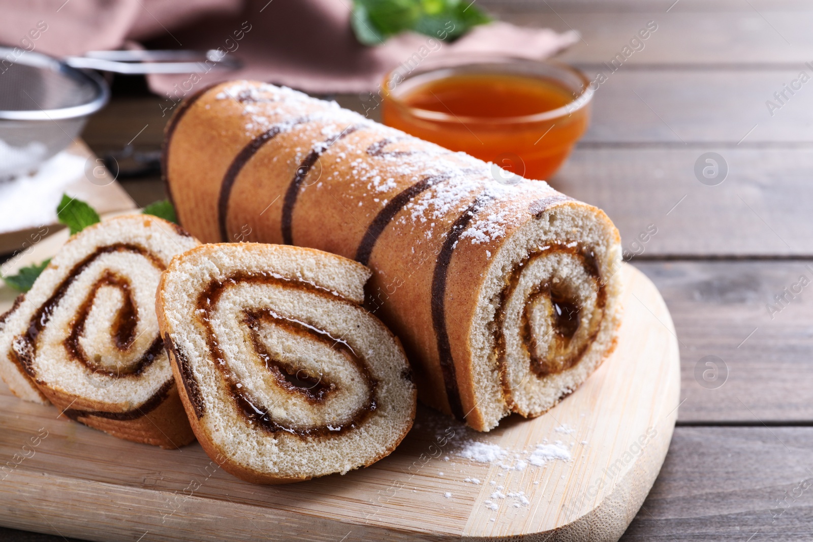 Photo of Tasty cake roll with jam on wooden table