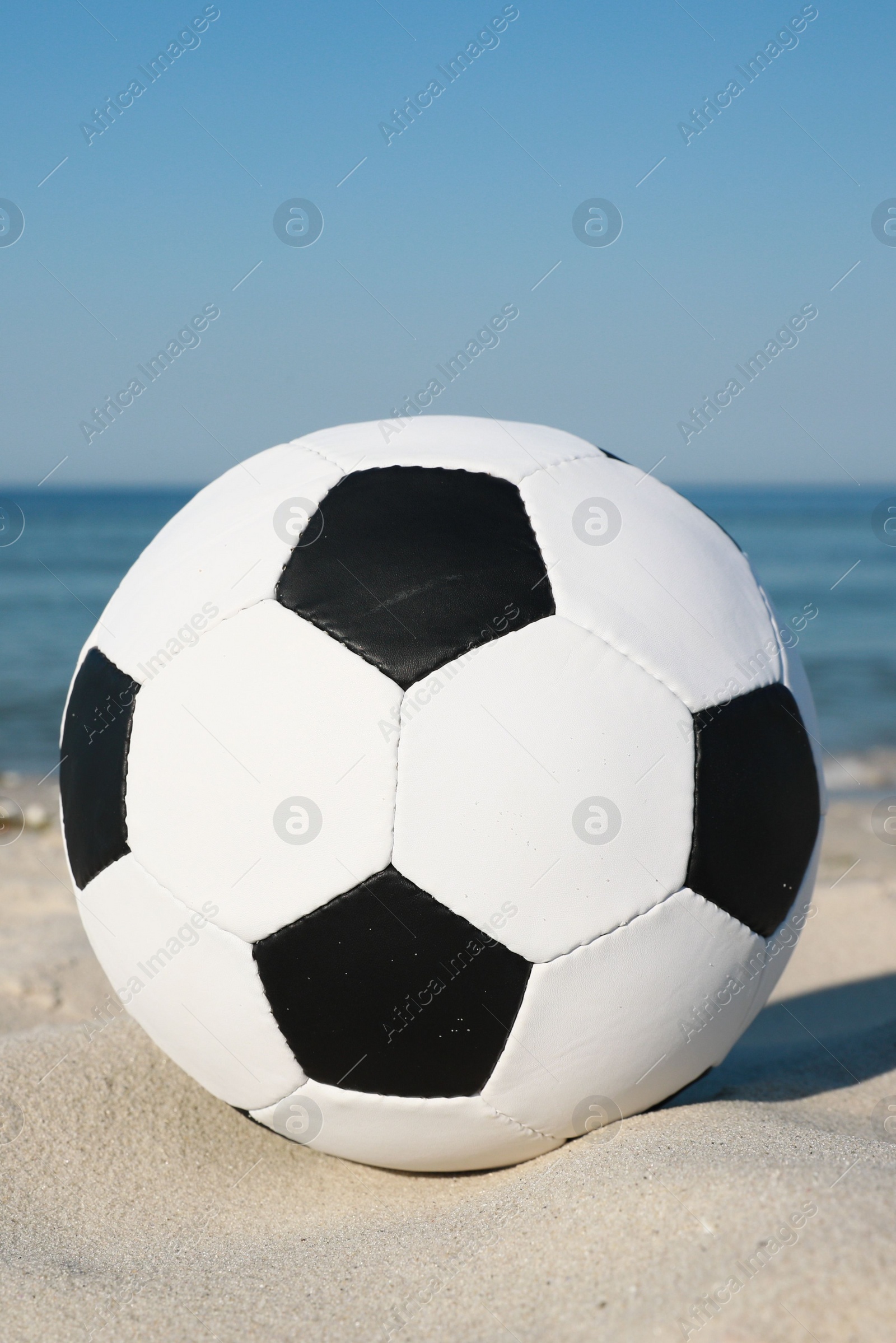Photo of Soccer ball on beach near sea. Football equipment