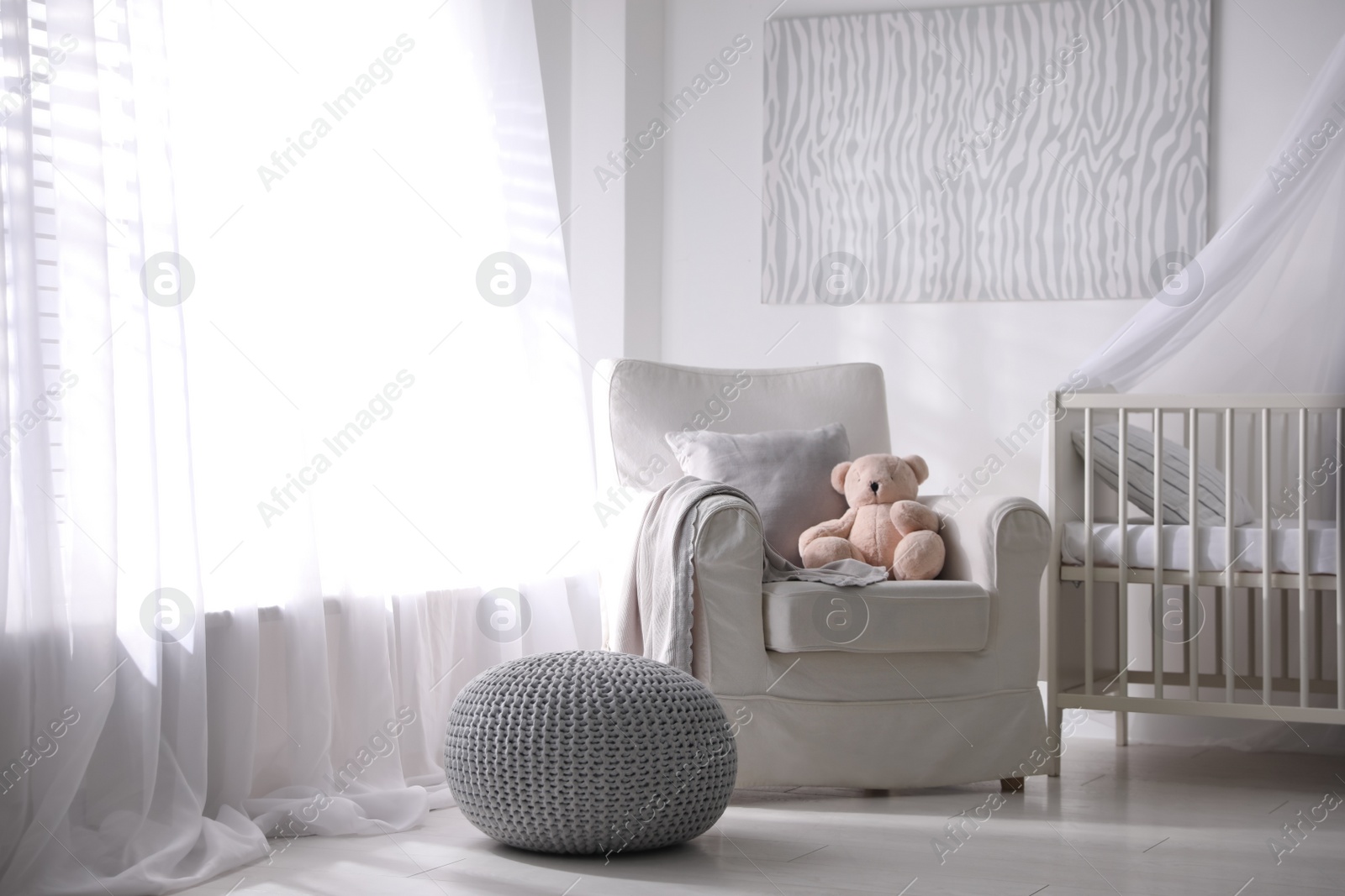 Photo of Baby room interior with comfortable crib and armchair