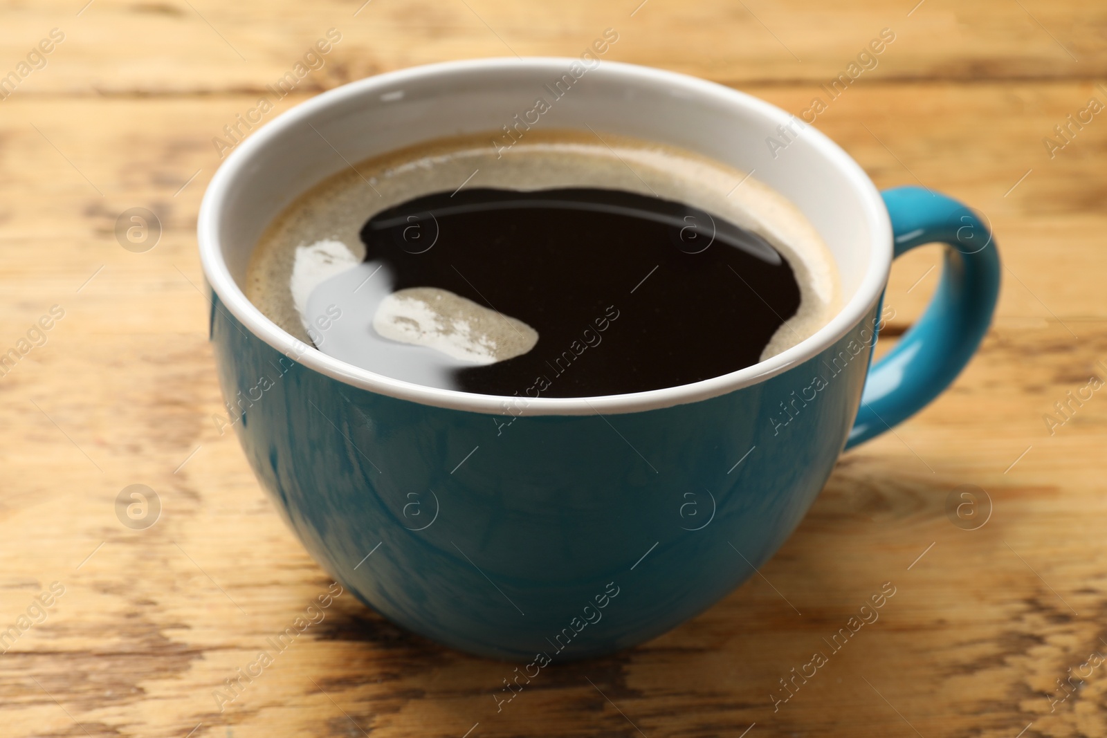 Photo of Cup of aromatic coffee on wooden table, closeup