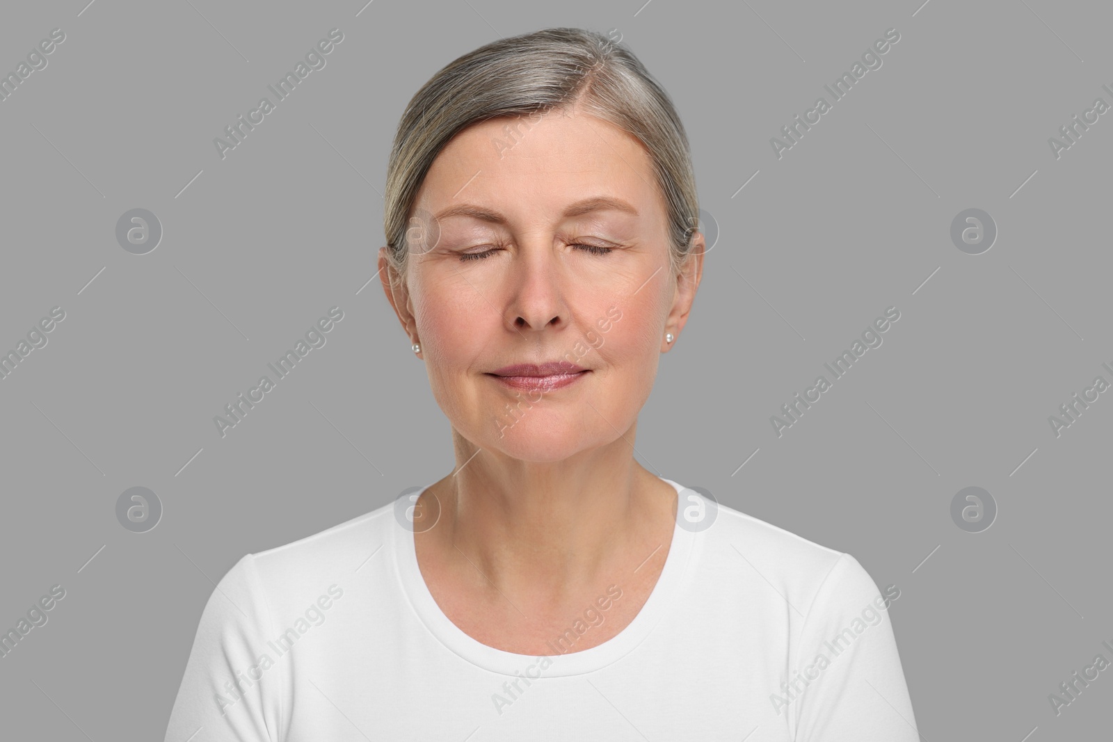 Photo of Portrait of senior woman with aging skin on grey background. Rejuvenation treatment