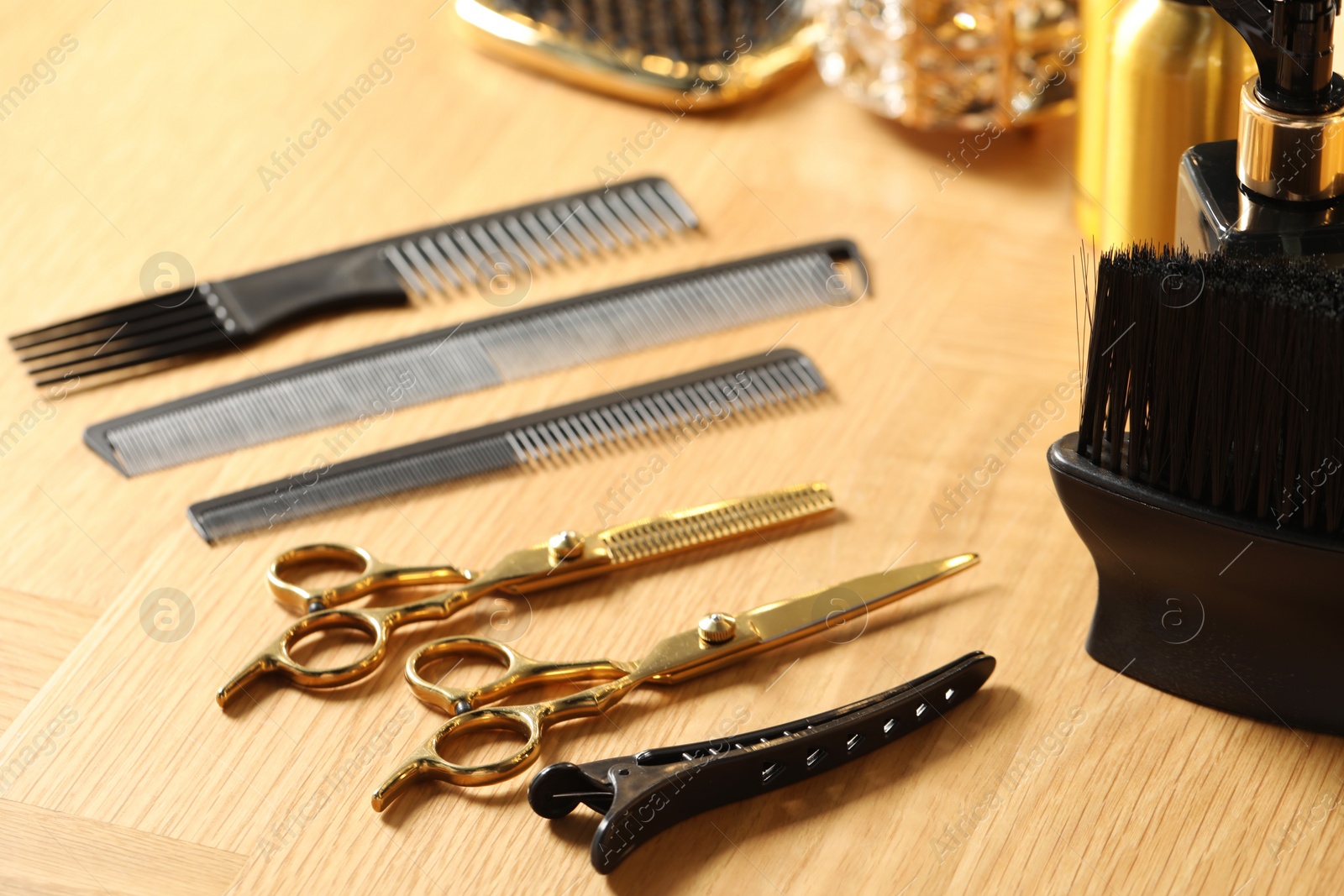 Photo of Hairdresser tools. Different scissors and combs on wooden table, closeup