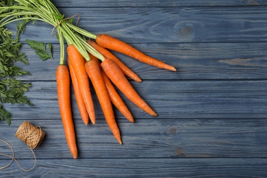 Photo of Flat lay composition with carrots on wooden background. Space for text