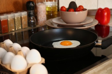 Frying eggs for breakfast in kitchen, selective focus