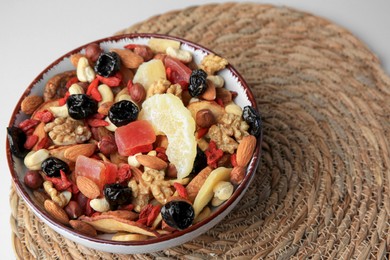 Bowl with mixed dried fruits and nuts on table, space for text