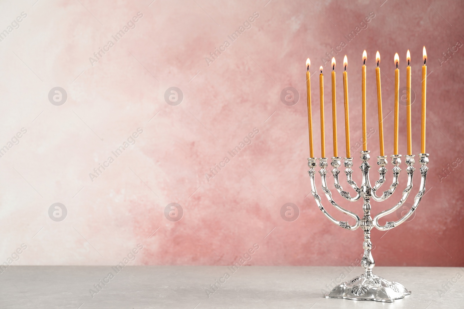 Photo of Hanukkah menorah on table against color background