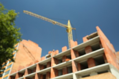 Photo of Blurred view of unfinished building and tower crane outdoors