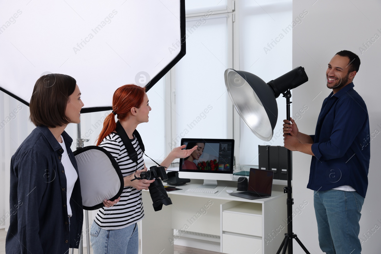 Photo of Young professional photographers working in modern photo studio