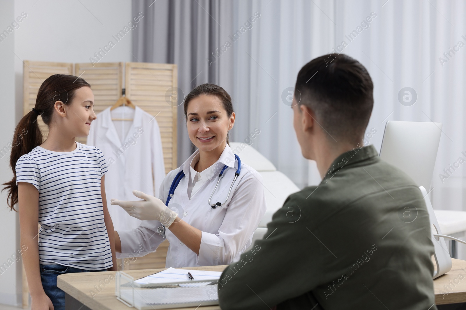 Photo of Gastroenterologist examining girl with stomach ache in clinic