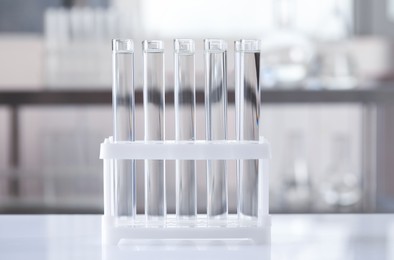 Photo of Test tubes with transparent liquid on table in laboratory