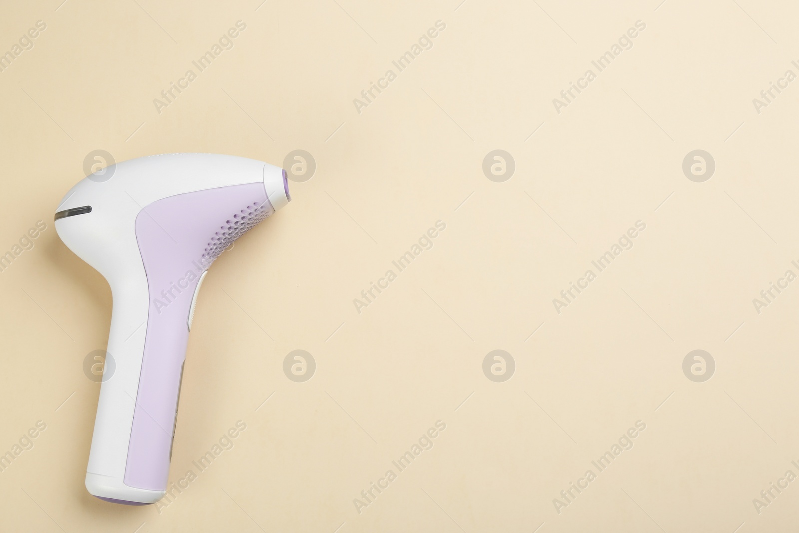 Photo of Modern photoepilator on beige background, top view. Space for text