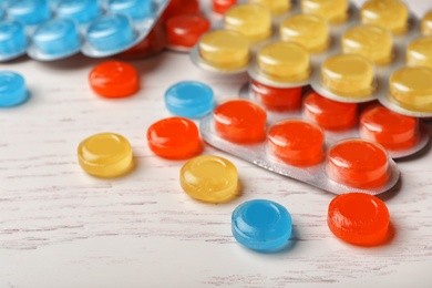 Photo of Color cough drops on wooden background