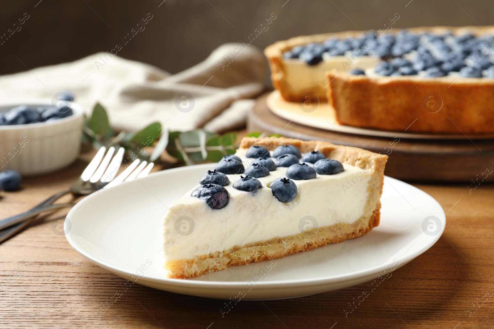 Photo of Plate with tasty blueberry cake on wooden table