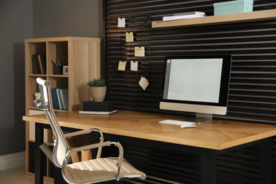 Photo of Comfortable workplace with office chair and computer on wooden table