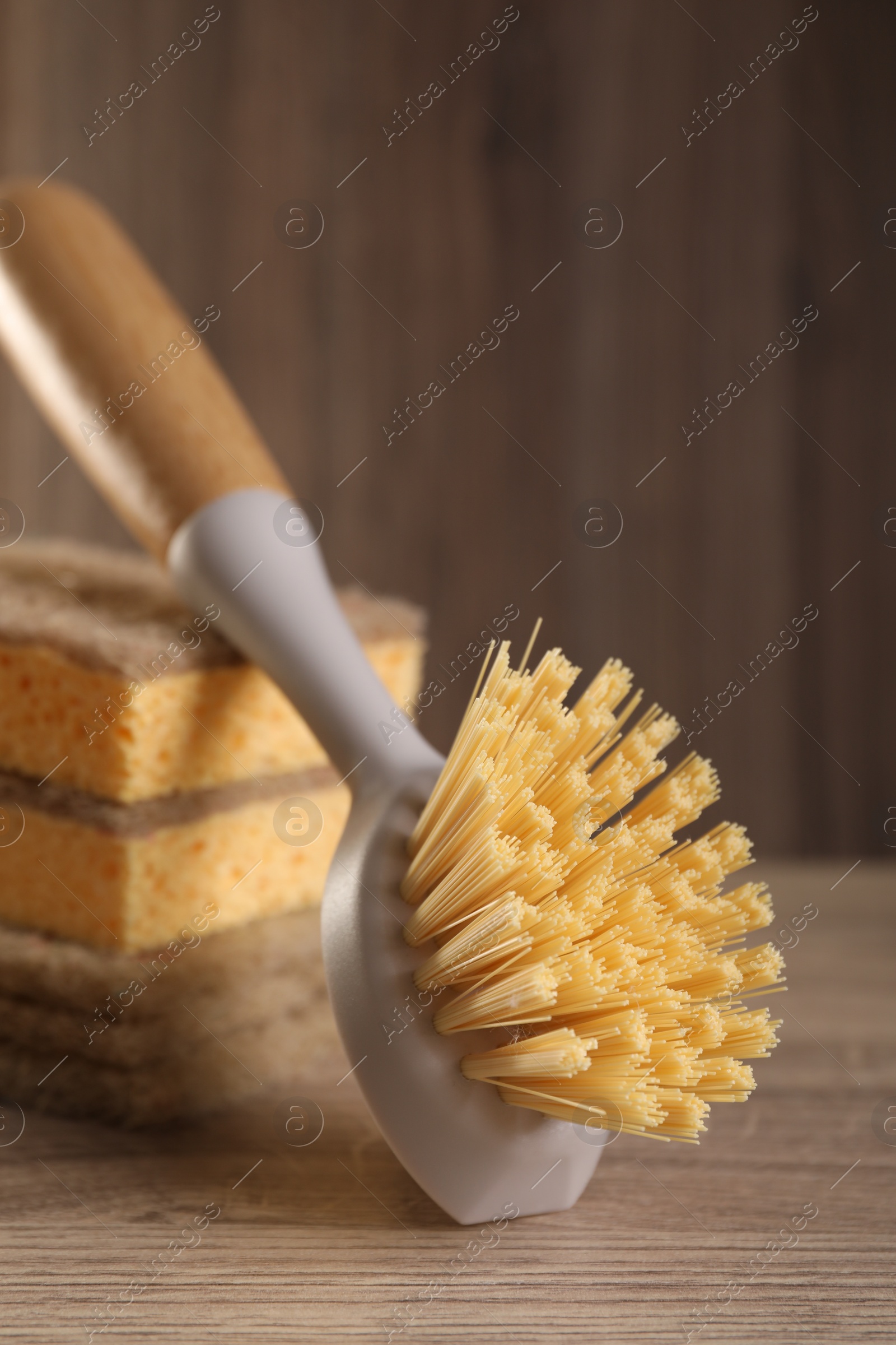 Photo of Cleaning brush and sponges on wooden table