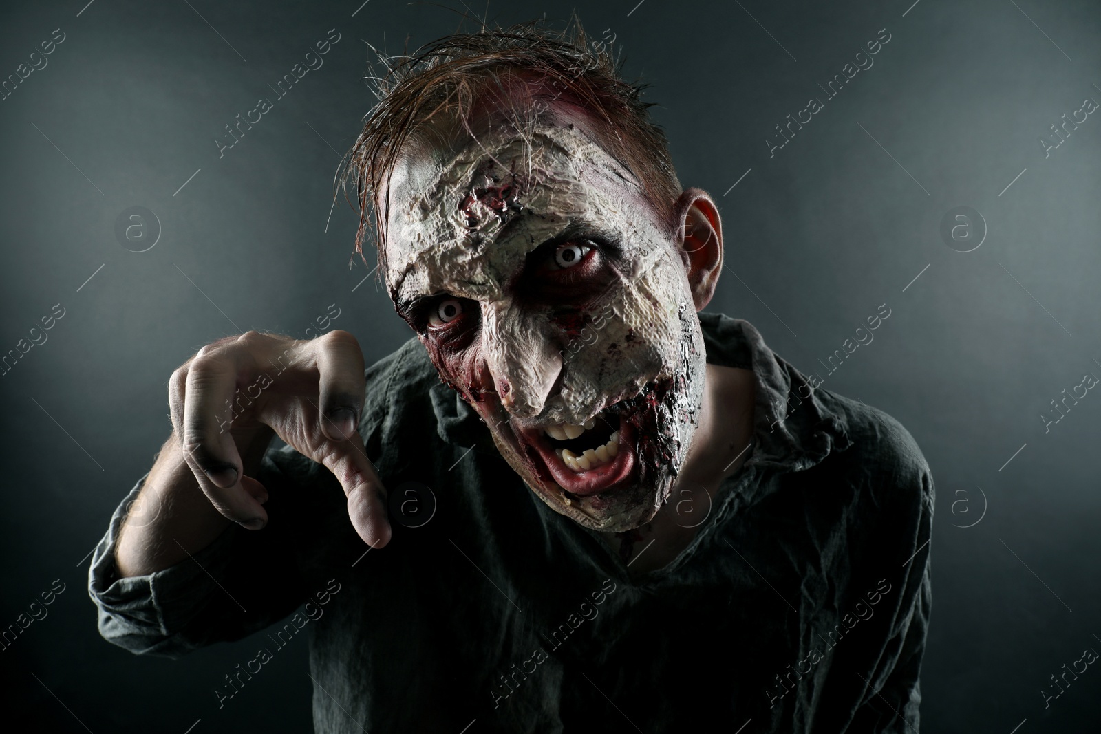 Photo of Scary zombie on dark background. Halloween monster