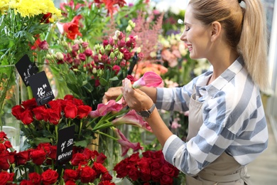 Photo of Beautiful female florist working in flower shop