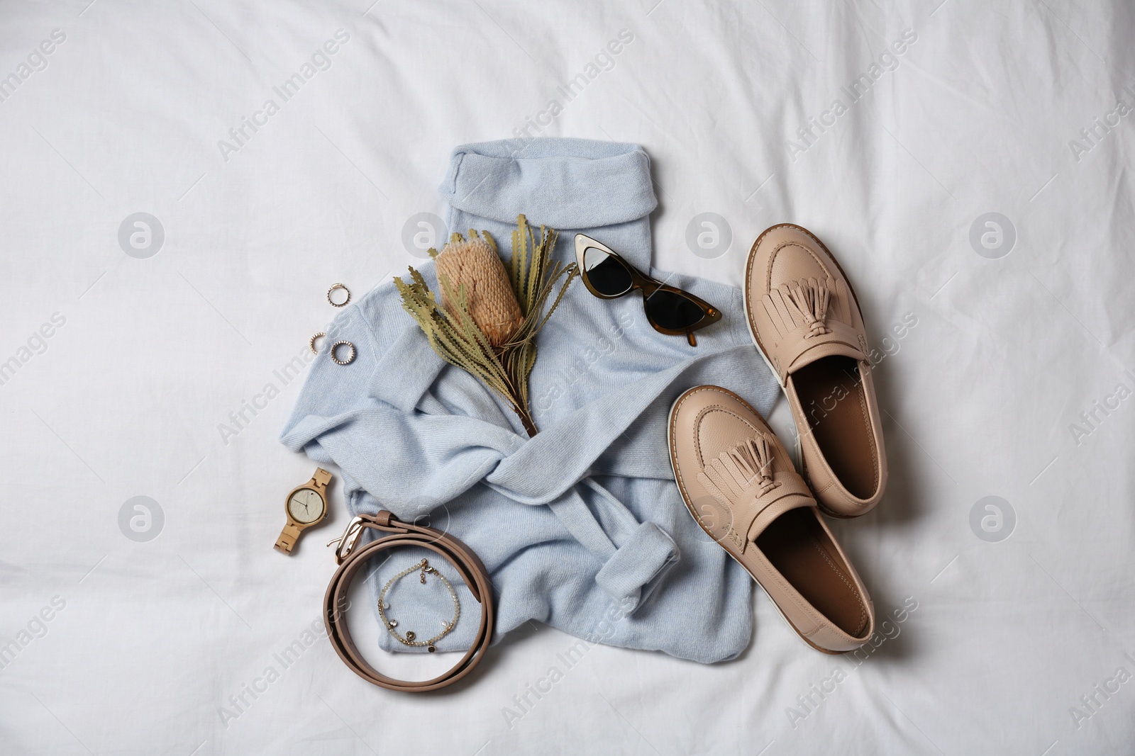 Photo of Stylish look with cashmere sweater, flat lay. Women's clothes and accessories on fabric