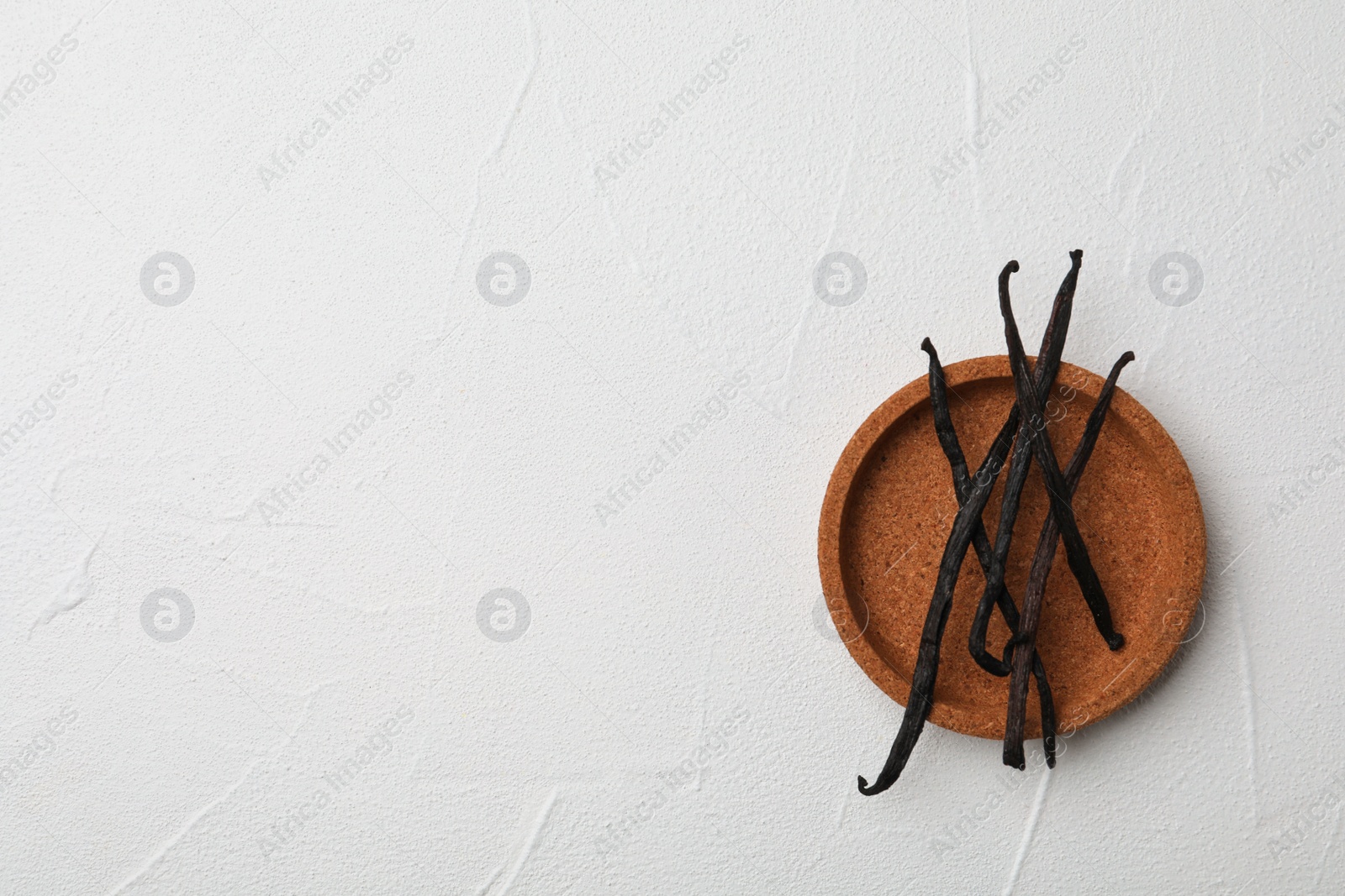 Photo of Plate with aromatic vanilla sticks on white background