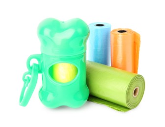 Photo of Rolls of colorful dog poop bags and holder isolated on white