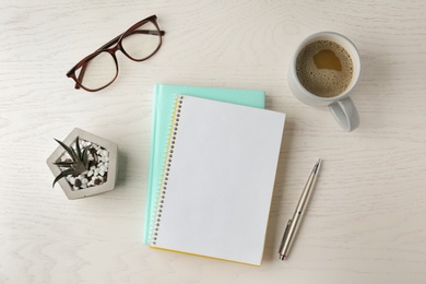 Photo of Flat lay composition with office stationery and cup of coffee on white wooden table. Space for design