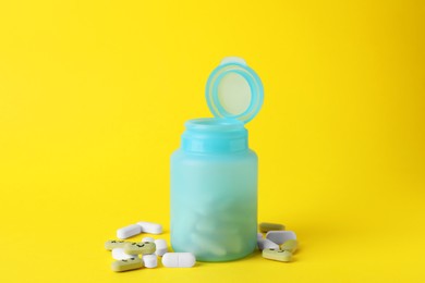 Photo of Different antidepressants with happy emoticons and medical jar on yellow background