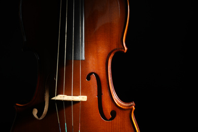 Photo of Classic violin on black background, closeup view