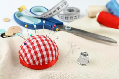Photo of Different sewing accessories on white background, closeup