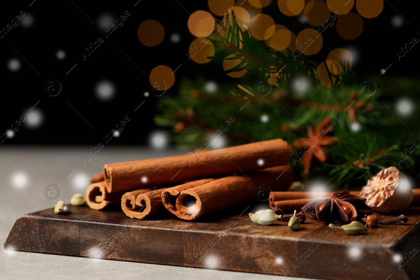 Image of Different spices and fir tree branches on grey table, closeup. Cinnamon, anise, cardamom, cloves, nutmeg