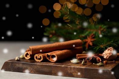 Image of Different spices and fir tree branches on grey table, closeup. Cinnamon, anise, cardamom, cloves, nutmeg