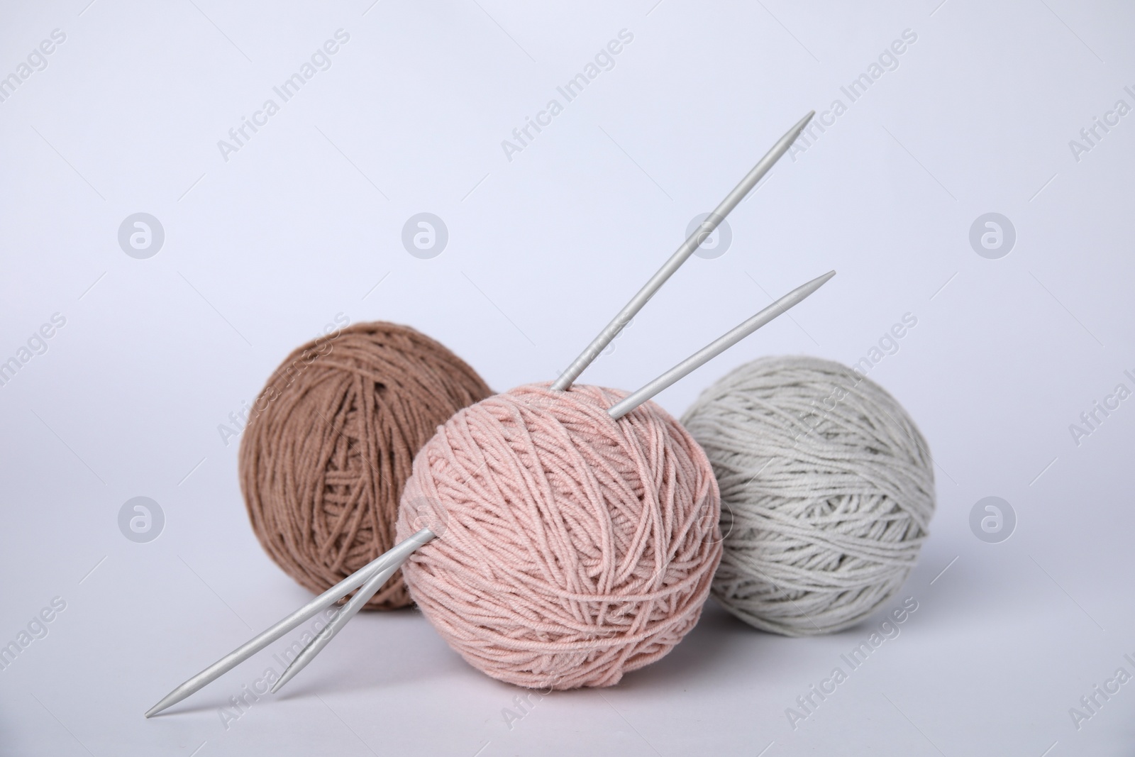 Photo of Soft woolen yarns and knitting needles on white background