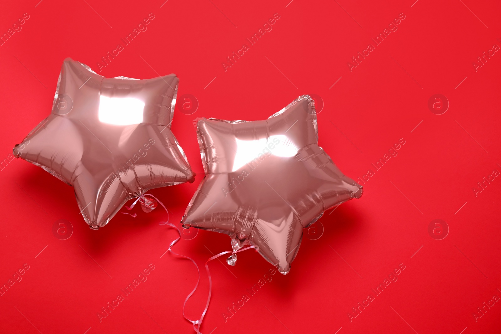 Photo of Star shaped pink balloons on red background, flat lay