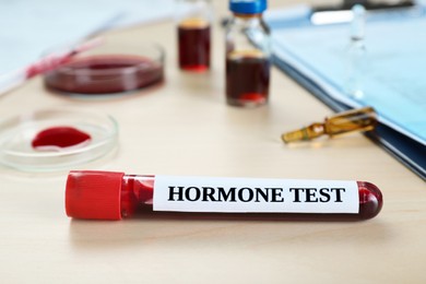 Photo of Hormone test. Sample tube with blood on table, closeup
