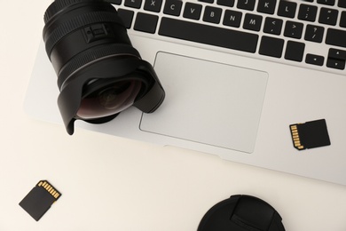 Photo of Laptop and professional photographer's equipment on table, top view