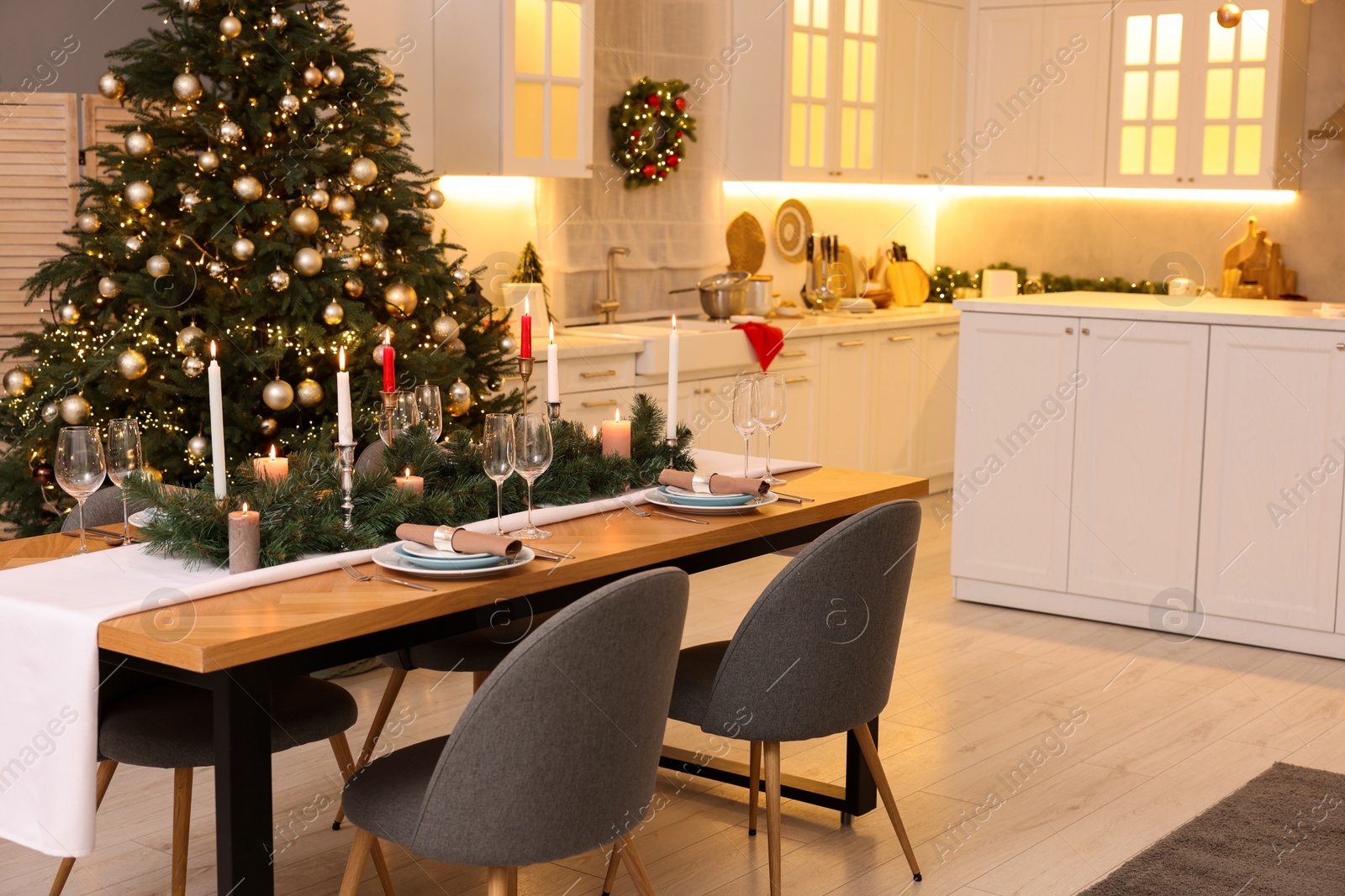 Photo of Festive table setting and beautiful Christmas decor in kitchen. Interior design