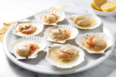 Photo of Fried scallops in shells on white marble table, closeup