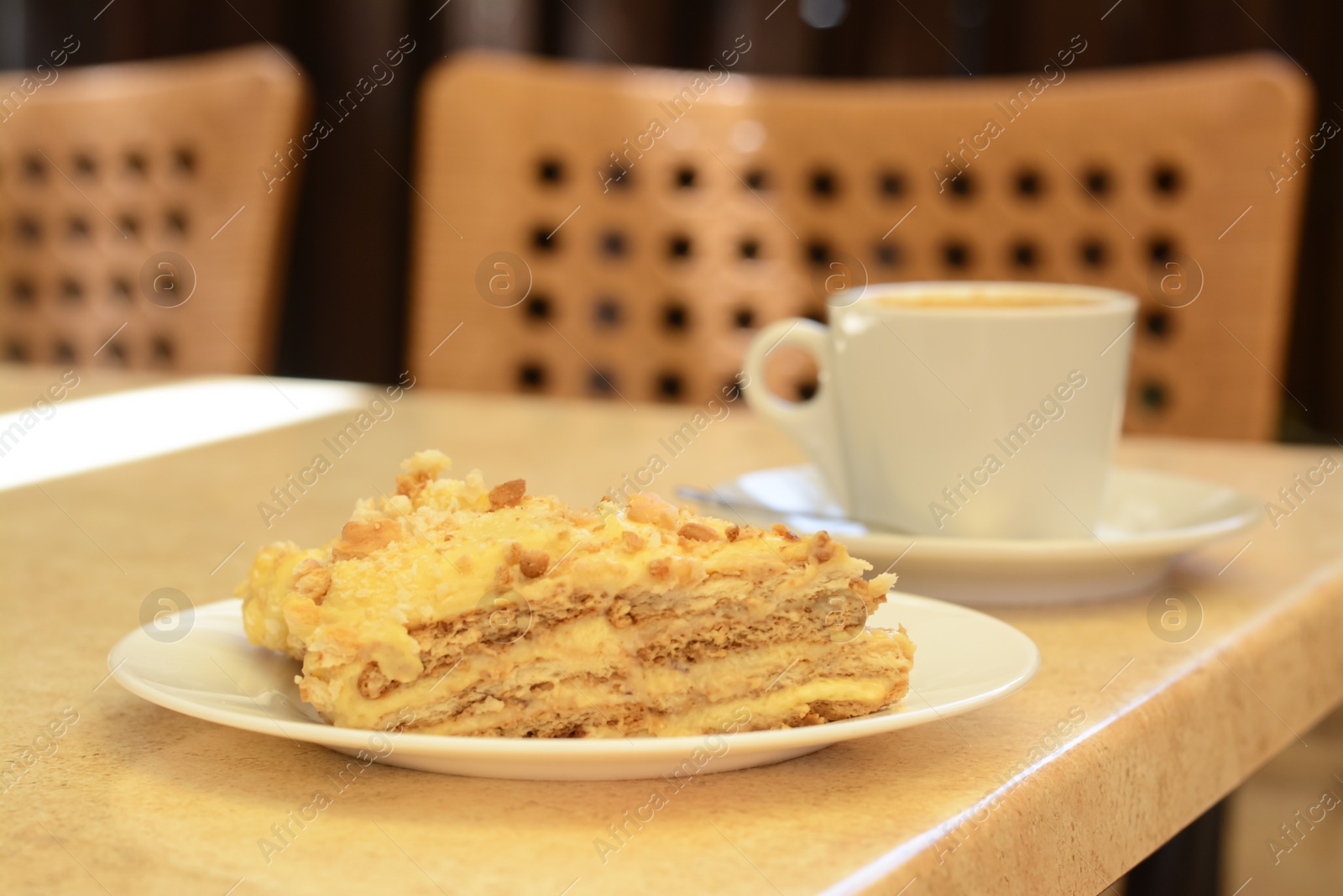 Photo of Piece of delicious cake and coffee on beige table, closeup