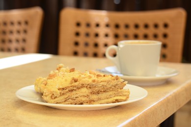 Piece of delicious cake and coffee on beige table, closeup