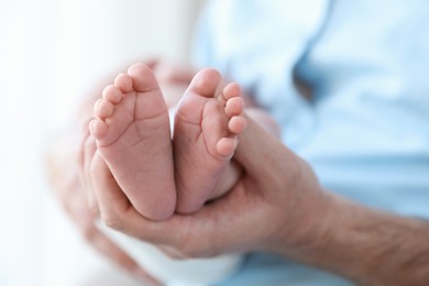 Father holding his newborn baby at home, closeup. Space for text