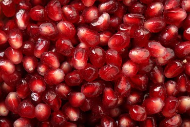 Photo of Ripe juicy pomegranate grains with water drops as background, top view