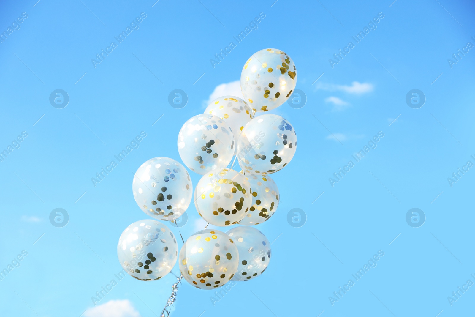 Photo of Glitter balloons against blue sky on sunny day outdoors