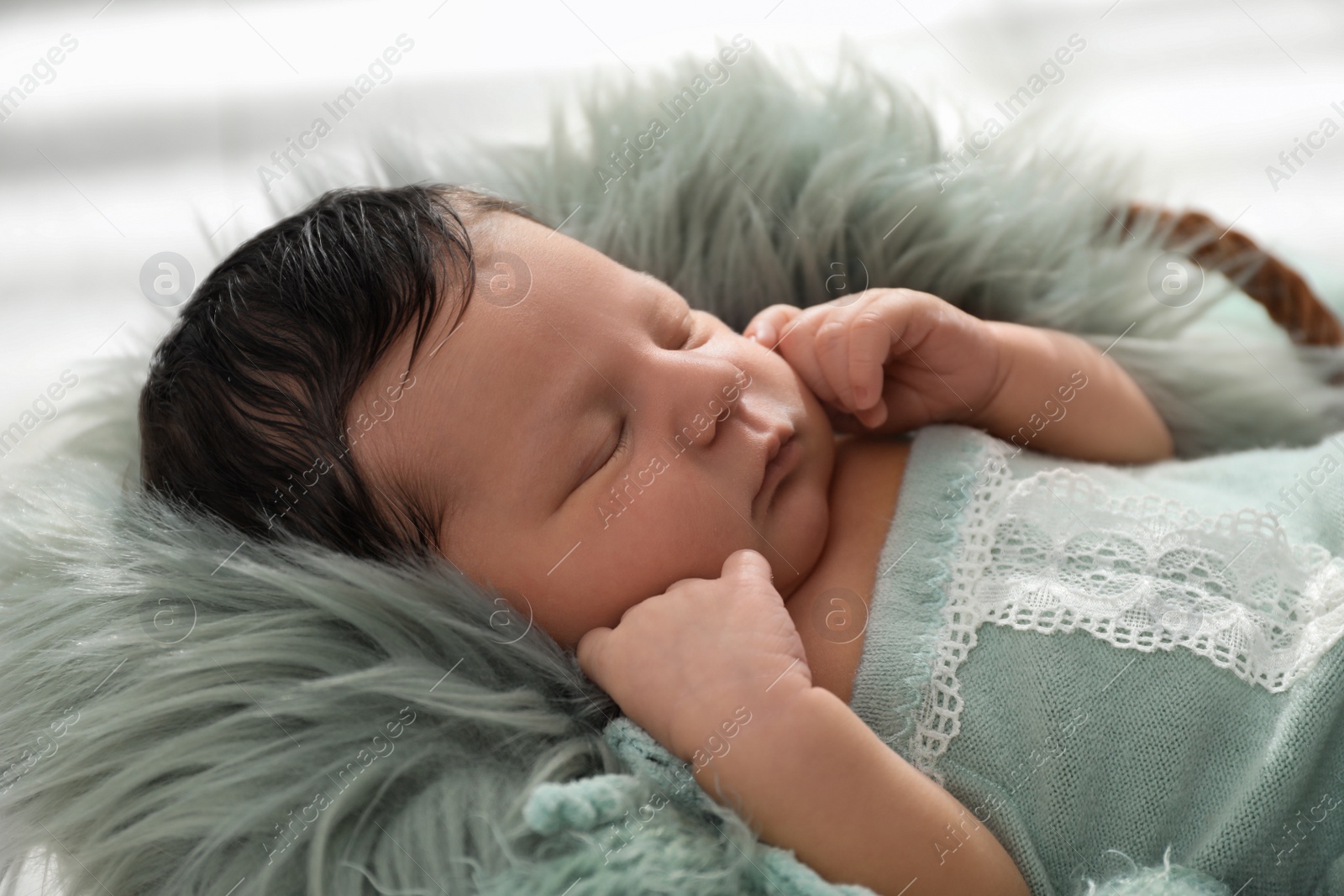 Photo of Cute newborn baby sleeping in wicker basket, closeup