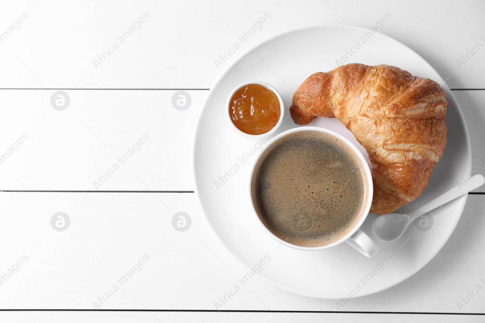 Photo of Breakfast time. Fresh croissant, jam and coffee on white wooden table, top view. Space for text