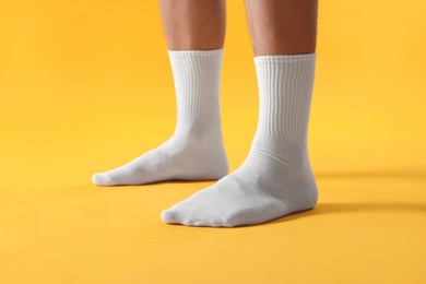 Photo of Man in stylish white socks on yellow background, closeup