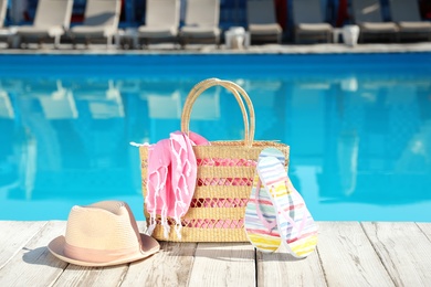 Beach accessories on wooden deck near outdoor swimming pool