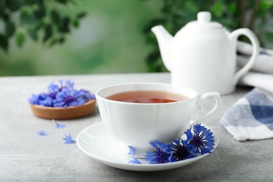 Photo of Cup of tea and cornflowers on light table