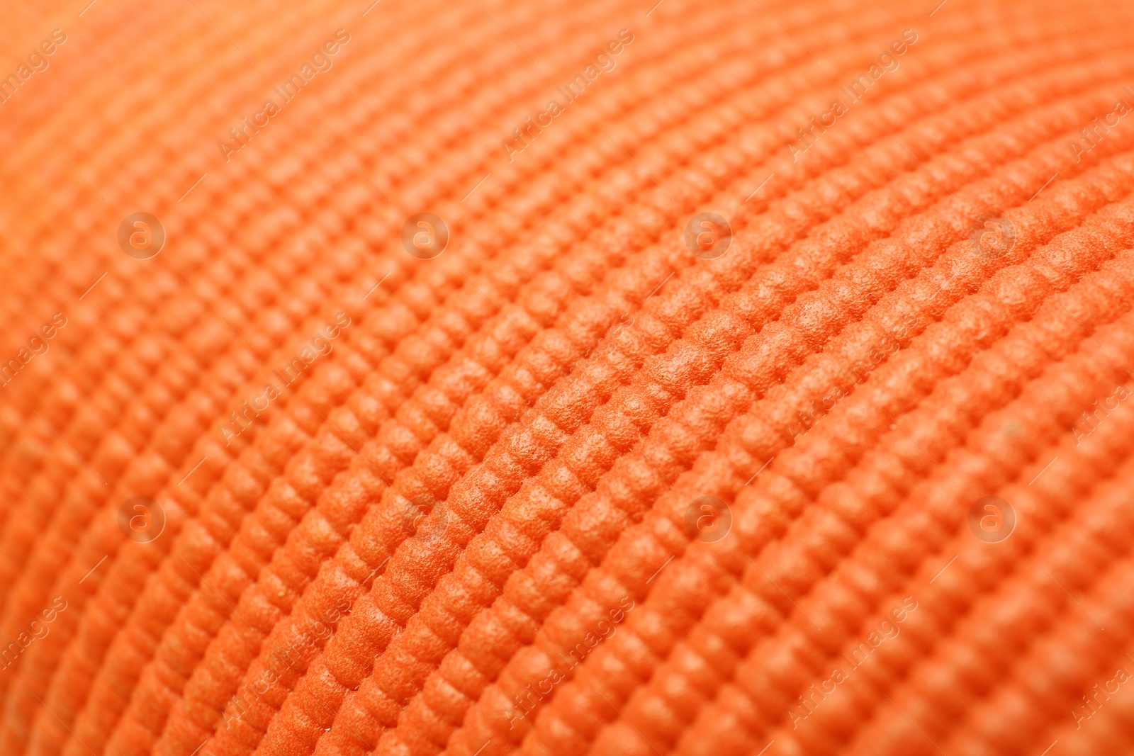 Photo of Orange foam rubber mat as background, closeup view